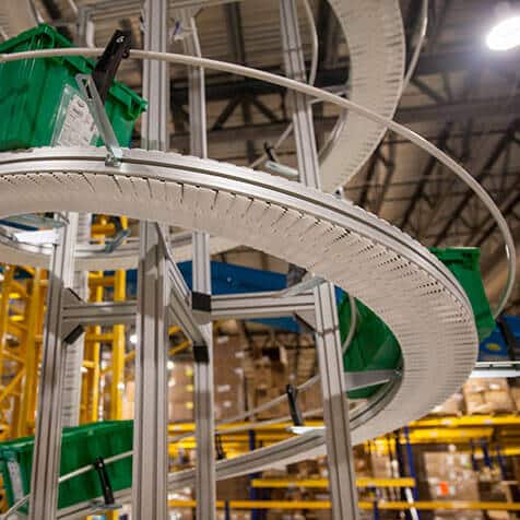 Totes move on a spiral conveyor with a module belt.