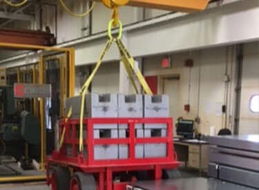 An underhung crane lifts a heavy load.