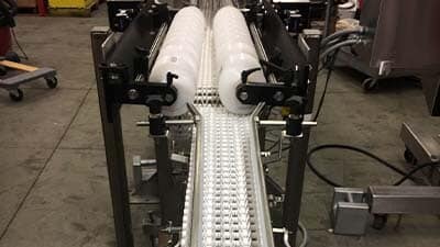 Stretch wrapping devices are shown at the end of a conveyor.