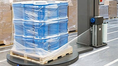 A semi-automatic stretch wrap machine wraps a pallet of pails.