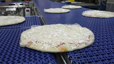 Shrink wrapped pizzas on a conveyor belt