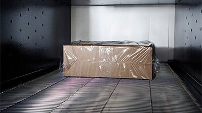 A shrink wrapped carton on a conveyor system