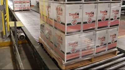 A pallet of shrink-wrapped cartons moves on a conveyor.