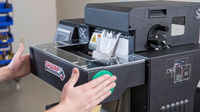 A person uses a Sharp bagging machine.