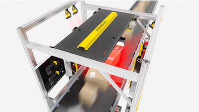 A robotic vision system scans cartons on a conveyor.
