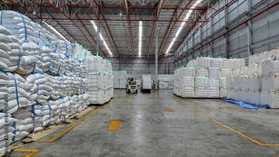Large bags rest on pallets in a warehouse.