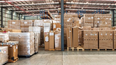 Shrink wrapped pallets of cartons in a warehouse.