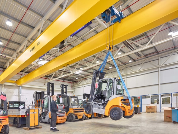 A Demag overhead crane is used to move a forklift.