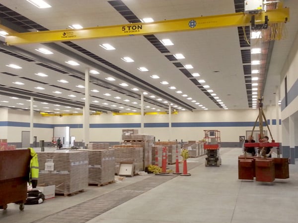 An underhung crane moves items in a warehouse.